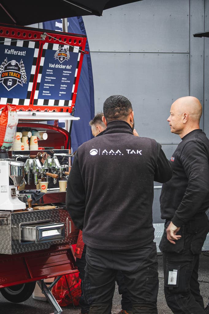 a group of men standing next to a coffee machine