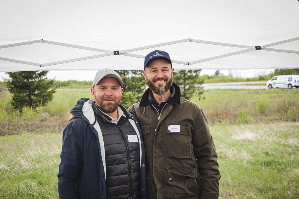 two men standing under a tent