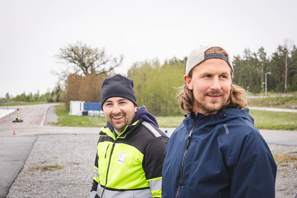 two men standing outside smiling
