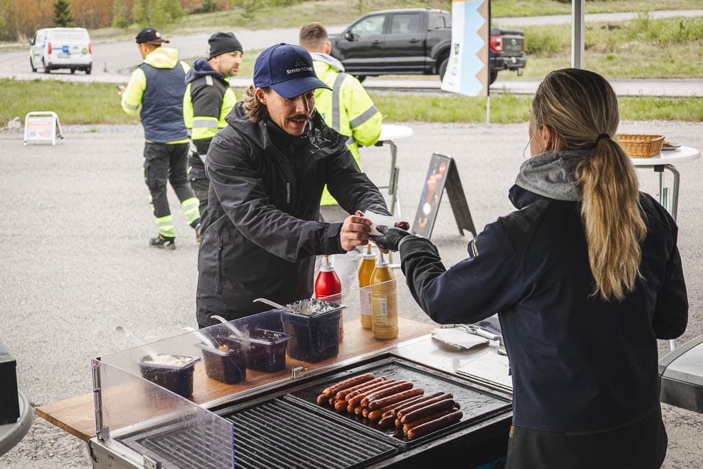a man handing a hot dog to a woman