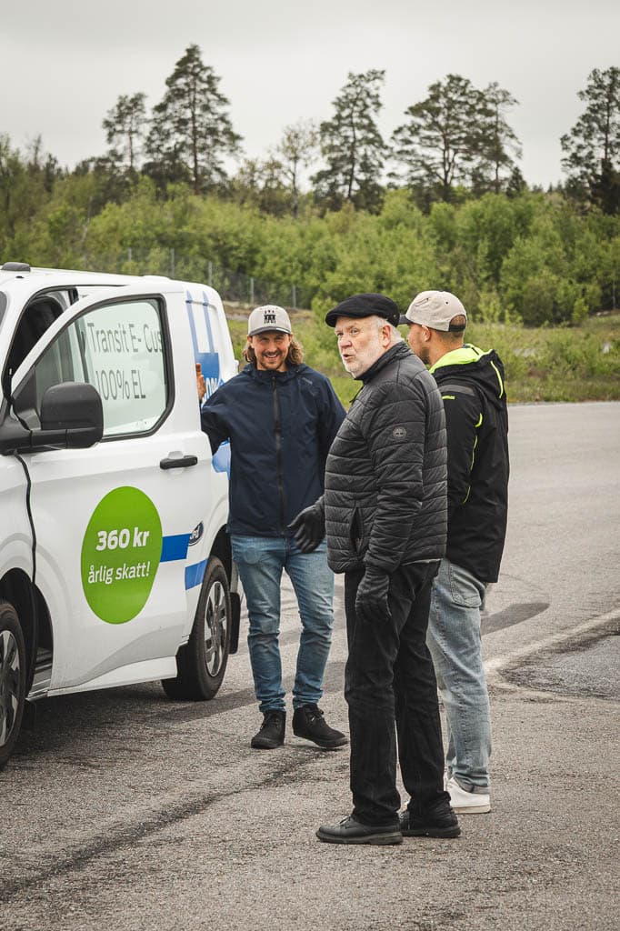 a group of men standing next to a white van