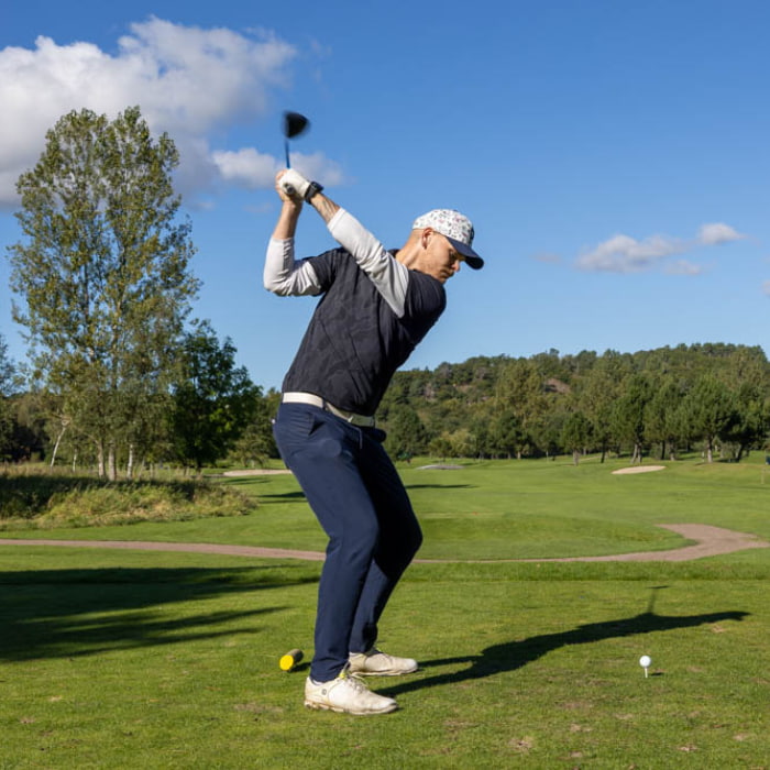 Kille som slår ut en golfboll
