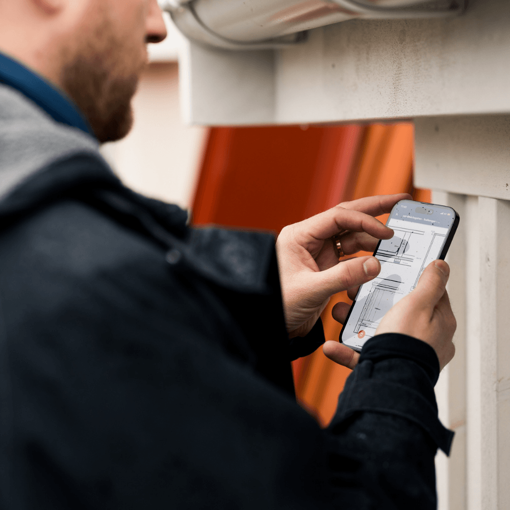 Person använder telefon för byggplaner